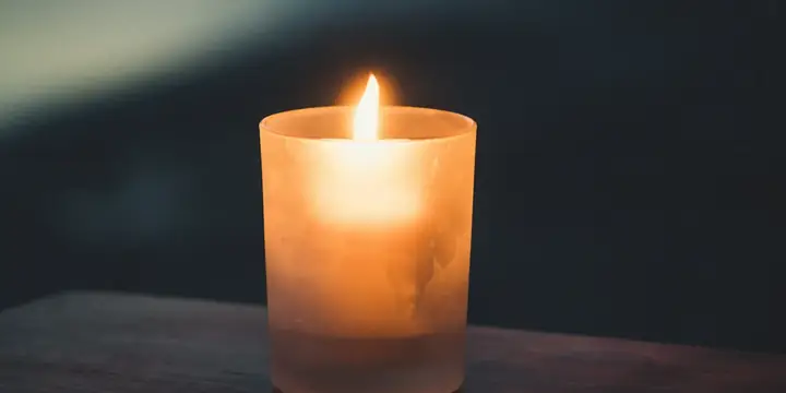 A single candle glowing softly in a dark room